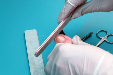 Preparing nails for applying gel polish. Set of cosmetic tools for manicure and pedicure on a black background. Gel polishes, nail files and tongs and a lamp.の写真素材