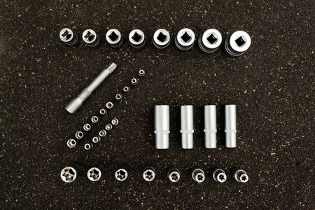 A set of tools, a complete set a six-sided key, a bit, a wrench. cardan joint, screwdriver-holder for bits, screwdriver handle, ratchet, extension cord Gray backgroundの写真素材