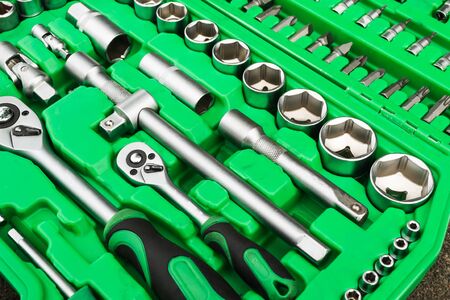 A set of tools, a complete set a six-sided key, a bit, a wrench. cardan joint, screwdriver-holder for bits, screwdriver handle, ratchet, extension cord Green tool caseの写真素材
