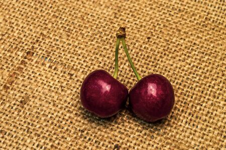 Red ripe juicy sweet cherry on a baggy napkin, blue backgroundの写真素材