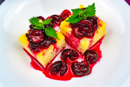Light breakfast. Two slices of cottage cheese casserole on a white plate, decorated with chopped...