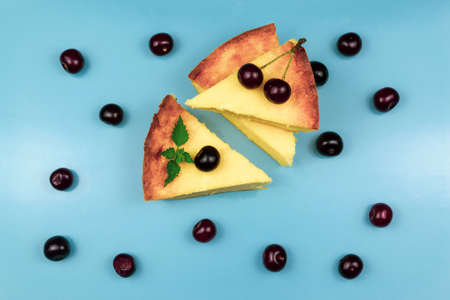 Light breakfast. Three pieces of casserole decorated with mint and cherry. Blue backgroundの写真素材