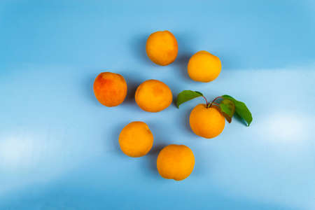 Ripe juicy apricots on a blue background