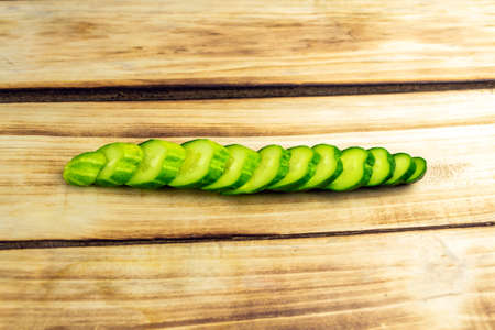 Sliced green cucumber on wooden background close-upの写真素材