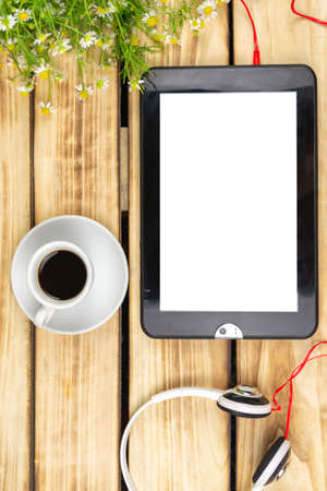 Tablet, coffee cup, headphones on a wooden background. Workplace of a businessmanの写真素材