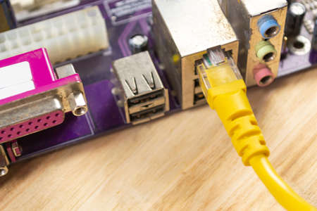 The wire is inserted into the motherboard. Wood backgroundの写真素材