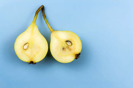 Two halves of a yellow pear lies on a blue backgroundの写真素材
