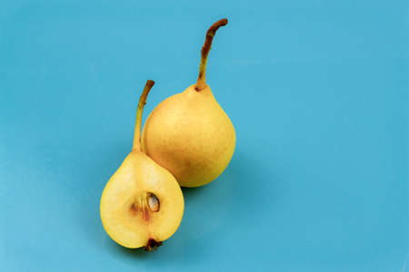 Yellow pears on a blue background. One cut in halfの写真素材