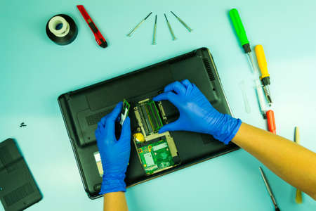 Disassembling a laptop in a repair shop. Cleaning service, support. Concept for computer equipment, repair.の写真素材