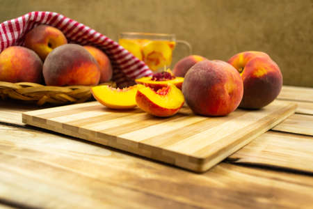 Peaches in a wicker plate, red napkin, cutting board with peaches and compote close-up. Wooden backgroundの写真素材