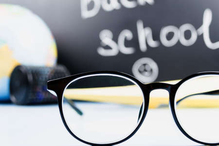 Glasses on the background of the school board and the globeSchool, training, the concept of obtaining knowledge.の写真素材