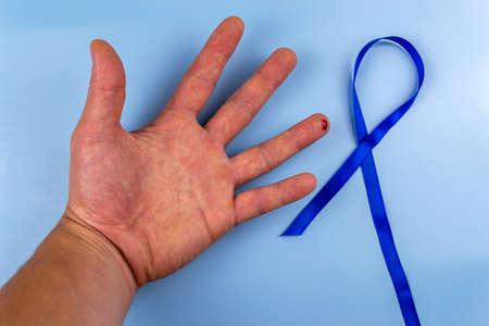 Male hand with a drop of blood on a finger and a sign of diabetes. World Diabetes Dayの写真素材