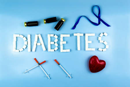 Lined with cubes of sugar diabetes, next to insulin syringes, a heart, bottles of insulin and a blue...