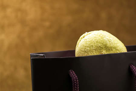 Macaroons climb out of a black bag close-up