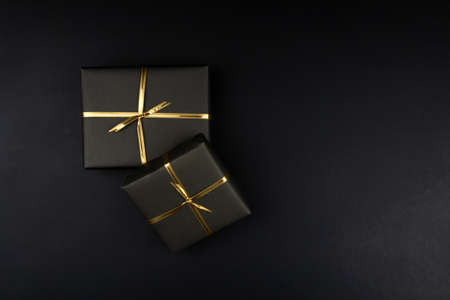 Gift boxes in black packaging on black background, black friday conceptの写真素材