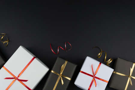 Gift boxes in black and white packaging on black background, black friday conceptの写真素材
