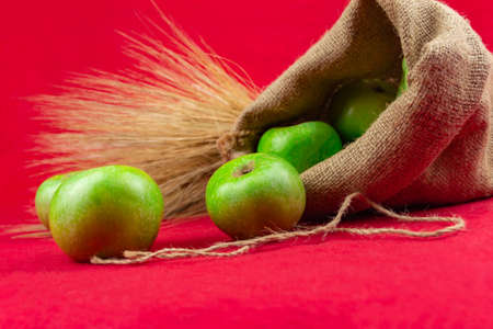 Green apples in a bag on a red background. Close-up