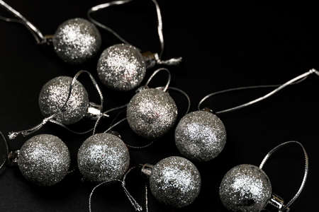 New Year's gray shiny balls lined with a triangle on a black background. Christmas and New Year...