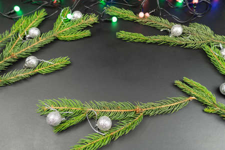 Fir branches are decorated with New Year's toys on a black background. Christmas, New Year, holidays, joy, fun.の写真素材
