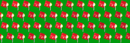Patern condom in red packaging on a green background. Medicine concept, campaign for World AIDS Day.の写真素材