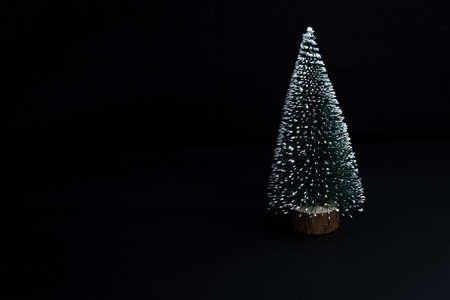 Artificial fir tree on a black background, free space for text. Copy space. Merry Christmas and Happy New Year.の写真素材