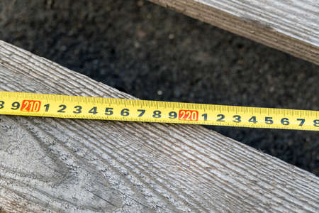 Old tape measure on the background of the blackboard. Measuring items