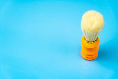 Orange shaving brush on blue background, copy space. Skin careの写真素材