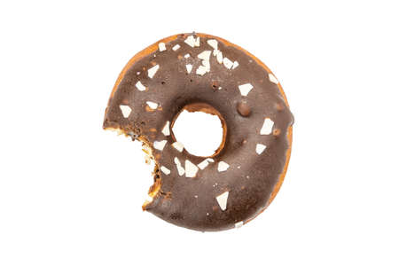 Bitten donut in chocolate glaze, sprinkled with pieces of white chocolate, isolated on white background. Delicious sweet but unhealthy food.の写真素材