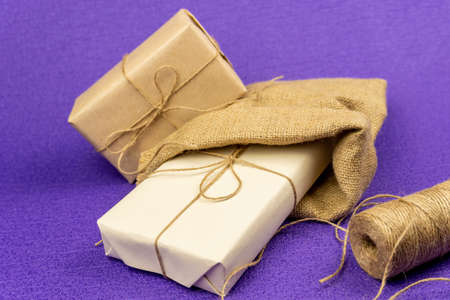 The gift is wrapped in yellowed paper and tied with a burlap rope, in a decorative bag and a skein...