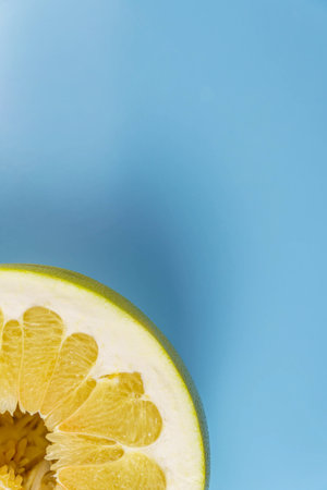 Top view of a half pomelo on a blue background. Free space for textの写真素材