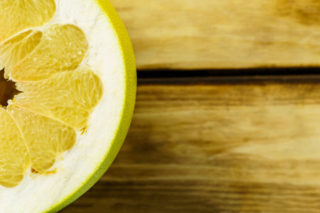Top view of half pomelo on wood background. Free space for writing textの写真素材