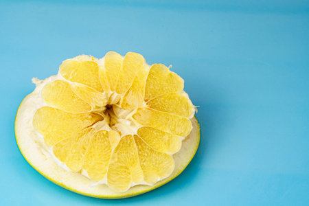 Part of the pomelo peeled from the fruit on a blue background. Free space for textの写真素材