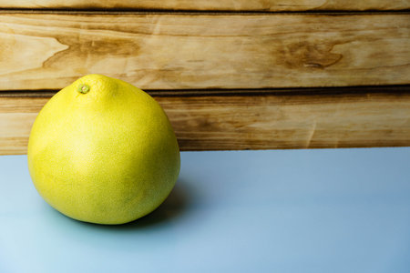 Yellow pomelo on a blue background. Free space for entering textの写真素材
