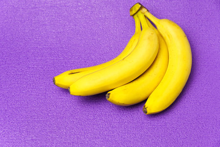 A bunch of bananas, on a violet background. Healthy lifestyle and proper nutrition.の写真素材