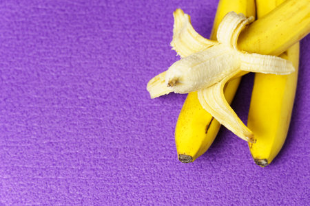 A bunch of bananas, on a violet background. Healthy lifestyle and proper nutrition.の写真素材