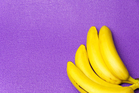 A bunch of bananas, on a violet background. Healthy lifestyle and proper nutrition.の写真素材
