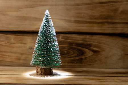Artificial Christmas tree on a wooden background, shallow depth of field. Christmas background with copy spaceの写真素材
