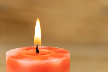 Red candle on a wooden background, shallow depth of field. Romantic background. Free space for textの写真素材