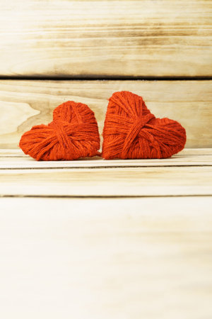 Two hearts on a wooden background. Hearts are made from red threads, with copy space. The concept of romance, love. Valentine's day shallow depth of fieldの写真素材