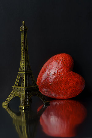 Elfel tower and near red heart on a black background. Free space for text postcard for Valentine's Day.の写真素材