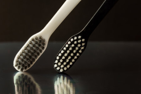 Close-up of black and white toothbrushes on a black background. Oral hygiene conceptの写真素材