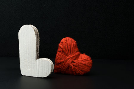 Volumetric letter L and a heart on a black background. Valentines day card
