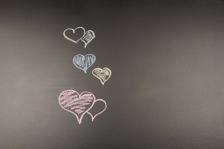 Hearts drawn in chalk on a black background, with copy space. Valentine's day cardの写真素材