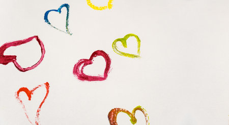 Multicolored hearts on a white background with copy space. The hearts are painted with multi-colored paints. Valentine's day cardの写真素材