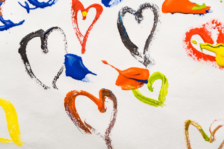 Colored hearts are smeared with paints on a white background. Drawing a card for Valentine's Dayの写真素材
