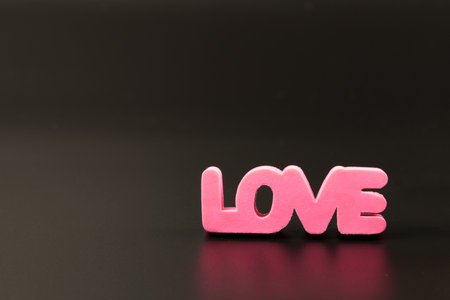 Volumetric pink letters of love on a black background with copy space. Valentines Day cardの写真素材