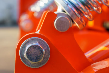 Close-up - bolt and shock absorber part of an agricultural seeder. Structural parts of agricultural machineryの写真素材