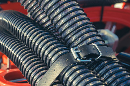 Close-up of a bundle of corrugated fertilizer pipes for an agricultural seeder. Structural details of agricultural machineryの写真素材