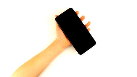 Hand holds black smartphone isolated on white backgroundの写真素材