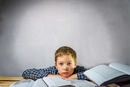 Tired schoolboy thinks lying on the table among the books. World Book and Copyright Day Free space...